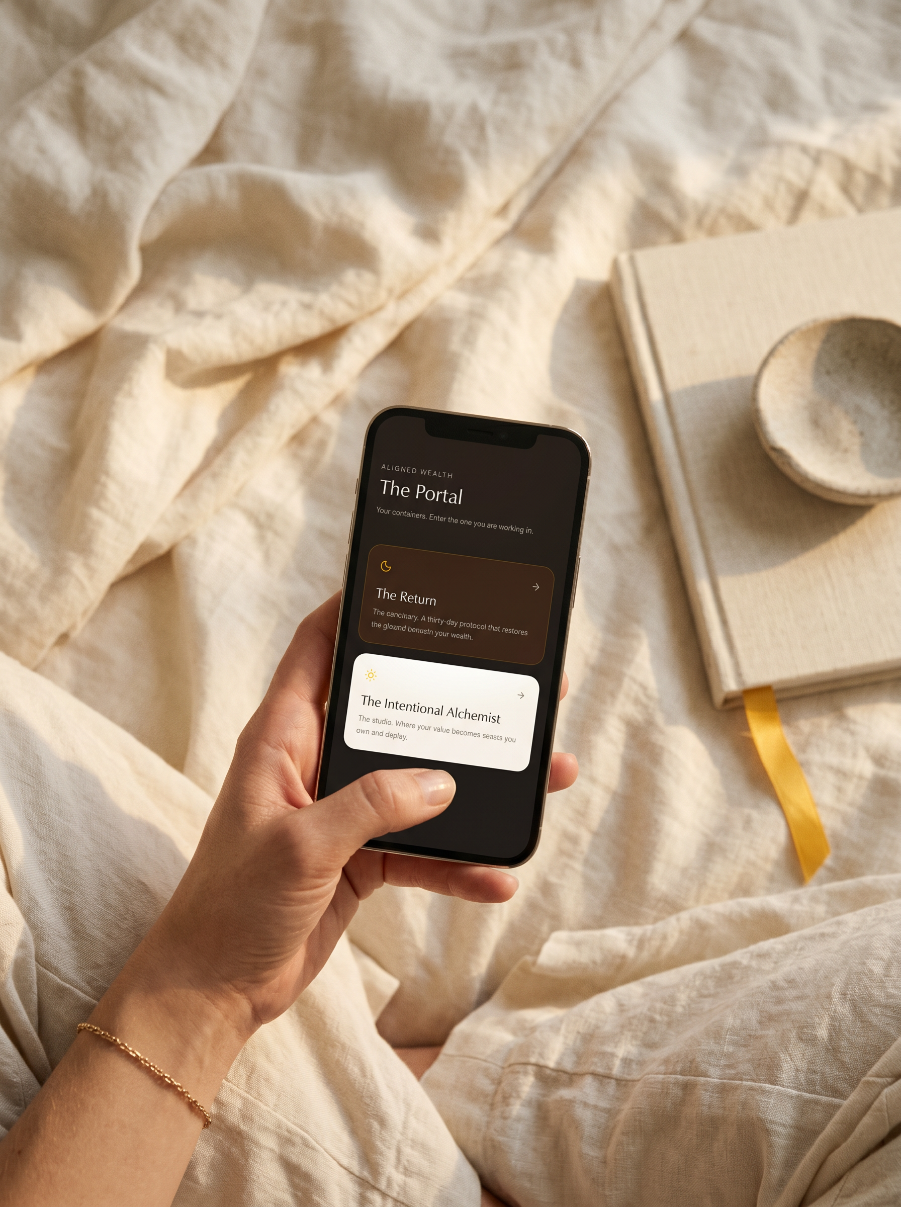 A woman's hand holding an iPhone on soft cream linen, screen showing the Aligned Wealth Portal with The Return and The Intentional Alchemist containers.